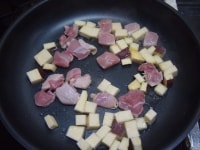 フライパンに油をひいて、赤唐辛子、薩摩芋、鶏肉を炒めます。