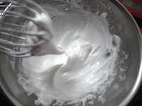 卵白をボウルに入れます。2～3回に分けてグラニュー糖を加えながら、泡立て器またはハンドミキサーで混ぜ、しっかりしたメレンゲを作ります。