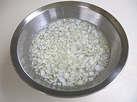 玉ねぎはみじん切りにして水に5分ほど浸けます。ザルにあげ、しっかりと水気を切っておきます。<br />
