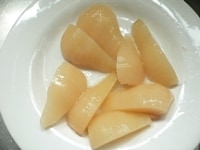 洋梨を半分（大きければ1/3～1/4）に切る。冷凍パイシートを出して少し柔らかくしておく。<br />
