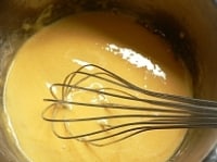 鍋に卵黄を入れて溶きほぐし、グラニュー糖と薄力粉を入れて泡だて器で混ぜる。<br />