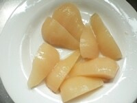 洋梨を半分（大きければ1/3～1/4）に切る。冷凍パイシートを冷凍室から取り出して、少し柔らかくしておく。<br />