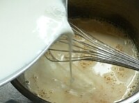 牛乳を沸騰直前まで温め、（4）に少しずつ加えて混ぜる。<br />