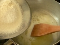 （1）に水と塩を入れて強火にかけ、バターが溶けたら弱火にして粉を一気に加え、木ベラで手早く混ぜる。<br />