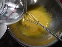 卵黄に残り半量の砂糖を加え、全体が白っぽくもったりとしてくるまでよく混ぜます。さらに水、サラダ油の順に加え、全体が滑らかになるまで混ぜます。