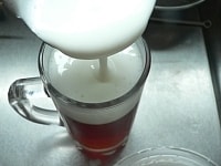 固まった紅茶ゼリーの上に、泡立てミルクゼリーをぎりぎりまでのせ、冷蔵庫に入れてしっかり固める。<br />