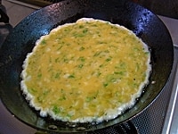 フライパンにバターを入れて溶かし、１を一気に流し入れ、大きくかき混ぜる。半熟状になったら片側によせてオムレツ形にまとめる。器に盛り、香菜、トマトなどを添える。