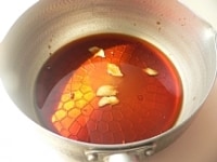 鍋に調味料、生姜、赤唐辛子を入れて加熱する