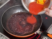 ハンバーグを焼き終わったフライパンに、肉汁などを残したまま、赤ワインを加えて沸騰させ、アルコールを飛ばす。そこに1のトマトを加え、ソースとバター、塩で調味する。