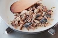 サバの水煮缶の水分を切り、身を取り出す。フライパンにニンニクと油を入れて熱し、ニンニクの香りが出たらサバの身を入れてざっくりと炒め、こしょうをふる。
