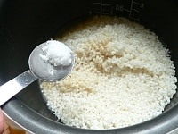 もち米を内釜にあけ（2）の漬け汁大さじ2・塩・昆布だしを入れ、おこわ用の線まで水を足し、軽く混ぜておこわ炊きで炊く。<br />
