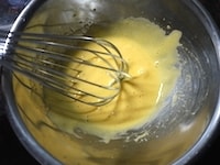 卵を卵白と卵黄にわけます。卵黄に半量のグラニュー糖を加え、泡立て器で白くもったりするまでよく混ぜます。<br />