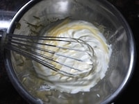 1の卵黄とホイップした生クリームを2回に分けて加え、泡立て器でよく混ぜます。<br />