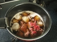 里芋を下茹でした湯は一度捨て、2カップの水を入れて再び火にかけます。沸騰したら牛肉、めんつゆ、醤油、砂糖を加えさらに3分程煮ます。