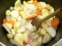 鍋にごま油を熱し、大根、にんじん、こんにゃく、里芋、じゃがいも、りんご、鶏肉を入れてじっくり2分ほど炒めたら、酒と水と牛蒡を入れて煮る。<br />