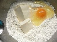 粉の真ん中に豆腐と卵とサラダ油を入れ、初めに卵と豆腐を手で混ぜ、次に粉と混ぜる。