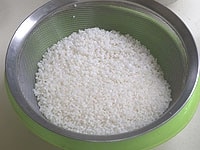 米はたっぷりの水で手早くかき混ぜて水を捨て、またたっぷりの水を加え洗い流すを3回ほど繰り返し、ざるに上げて水気を切っておきます。<br />