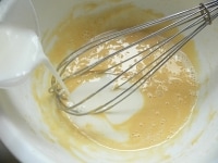 ボウルに卵と砂糖を入れて泡だて器でよく混ぜて、薄力粉をふるい入れてよく混ぜる。次に塩、リキュール、バニラエッセンスを入れてよく混ぜ、牛乳を少しずつ注いで混ぜる。<br />