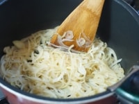鍋にサラダ油を熱し、ニンニクと玉ねぎを入れて炒めます。玉ねぎがしんなりとしたら、水とコンソメを入れて5分ほど煮込みます。