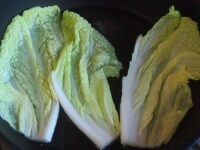 &nbsp;白菜を横半分に切り、さらに縦半分にする。葉先側はお湯でさっとゆがいてしんなりとさせ、芯の側は５mm幅程度に切っておく。