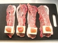 豚もも肉を1枚づつ並べます。手前側に4cm&times;4cmに切った高野豆腐とたらこをのせ、クルクルと巻き上げます。