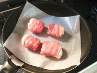 フライパンにオーブンシートをひき、肉巻きを並べて中火にかけ、表面がきつね色になるまで焼き付けます。