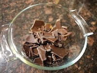 チョコレートを溶けやすい大きさに手で割り、耐熱容器に入れます。600Wの電子レンジに約2分かけ、チョコレートを溶かします。<br />
<br />
途中、チョコレートが焦げないように一度混ぜるようにして下さい。