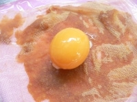 ガーゼ側を上にして置き、冷凍卵黄をのせる。<br />
<br />
※沢山漬ける場合はこちらのやり方で&rarr;<a href="http://allabout.co.jp/gm/gc/187474/">「生卵の黄身の味噌漬け」</a><br />
<br />
