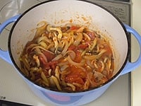 豚肉をもどし、トマト缶とトマトケチャップを加え、ひと煮立ちさせます。