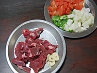 ラム肉、たまねぎ、ピーマン、トマトは1、5cm角に切る。にんにくは芽をとり、スライスする。