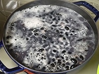 黒豆を洗い、豆の3倍の水に一晩浸けます。浸け水ごと鍋にかけ煮立つまでは中火で表面のアクを取り、弱火にして柔らかく煮ます。<br />