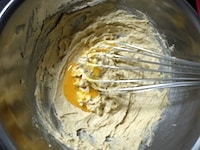 室温に戻した卵をときほぐし、2～3回に分けて加え、そのつど、なめらかなクリーム状になるまで泡立て器でよく混ぜます。