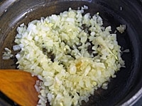 タジン鍋か蓋のできるフライパンにオリーブオイルを入れ、たまねぎ、ニンニクを炒める。