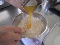 ボウルに合わせてふるった薄力粉とベーキングパウダー、きび砂糖を入れ木べらで軽く混ぜ、溶きほぐした卵を一度に加え混ぜます。