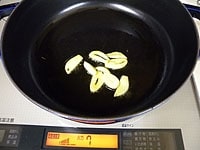 鍋にオリーブオイルとニンニクを入れ弱火にかけます。にんにくに焼き色が付いたら一度取り出します。