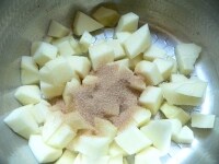 りんごは皮をむいて１cm角に切って鍋に入れ、砂糖を入れて火にかけ、りんごに砂糖をからめるようにしながら煮詰める。<br />