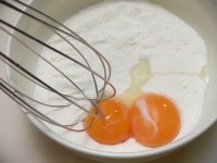 （1）の砂糖入り粉に、卵黄をよく混ぜる。<br />