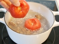 アクを取り、へたをとったトマトを加える。蓋をして１０分煮る。