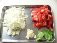 玉ねぎは粗みじん切りにする。トマトは1cm角に切る。ニンニクは薄く切る。<br />
