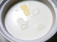 土鍋に冷たい牛乳とバターを入れる