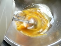 薄力粉は2回ふるう。バターは湯せんか電子レンジで溶かしておく。ボウルに熱めの湯を張り（50～60℃ぐらい）、別のボウルに卵とハチミツを入れ、底を湯にあてながら泡立てる。<br />