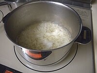 鍋に水とチキンブイヨンを入れて沸騰させます。ご飯を加えさっと煮ます。