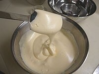 ボウルに卵を割り入れ泡立て器（ハンドミキサーでも良）で泡立てます。ボウルを湯煎（40～45度）にかけて砂糖を3回ほど分けて加えて白っぽくなるまで泡立てます。砂糖が溶けたら湯煎からはずし、リボン状になるまでしっかりと泡立てます。