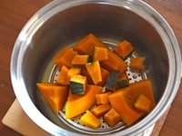 かぼちゃの種をくりぬき、作業しやすい大きさにかぼちゃを切ります。飾り用に3cm角の皮つきかぼちゃを10個ほど用意します。残りのかぼちゃは皮を切り落とし、8cm角くらいの乱切りにします。<br />
<br />
大きめの鍋に水を3cmほど入れて沸かし、かぼちゃを入れて、塩を振りかけて、蓋をして蒸し煮にします。<br />