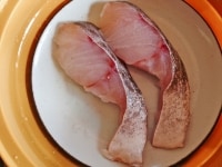 皿に白身魚を並べ、酒大さじ1をふり、ふたをして電子レンジで3分加熱します。<br />