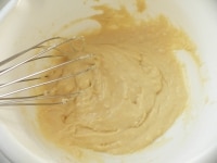 卵と牛乳を混ぜ、ホットケーキミックスを入れて混ぜ、溶かしバターを混ぜる。<br />