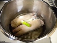 豚足は茹でたものが売られていますが。再度ねぎと生姜を加え茹でます。水1800ml、ねぎ、しょうがを入れて圧力鍋では10分ほど普通の鍋では30分ほど茹でます。 <br />