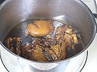 煮込み調味料の材料と豚足の肉の部分だけを鍋の入れて、20分ほど煮込みます。<br />
しっかりと味が染み込むように煮汁を回しかけます。<br />