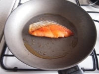 フライパンにオリーブオイル（大匙１杯）を敷き、鮭を入れて中火で両面焼き色が付くまで焼きます。