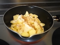 &nbsp;りんごを薄切りにし、グラニュー糖、シナモンパウダーを加え、鍋にいれ、中火で加熱します。